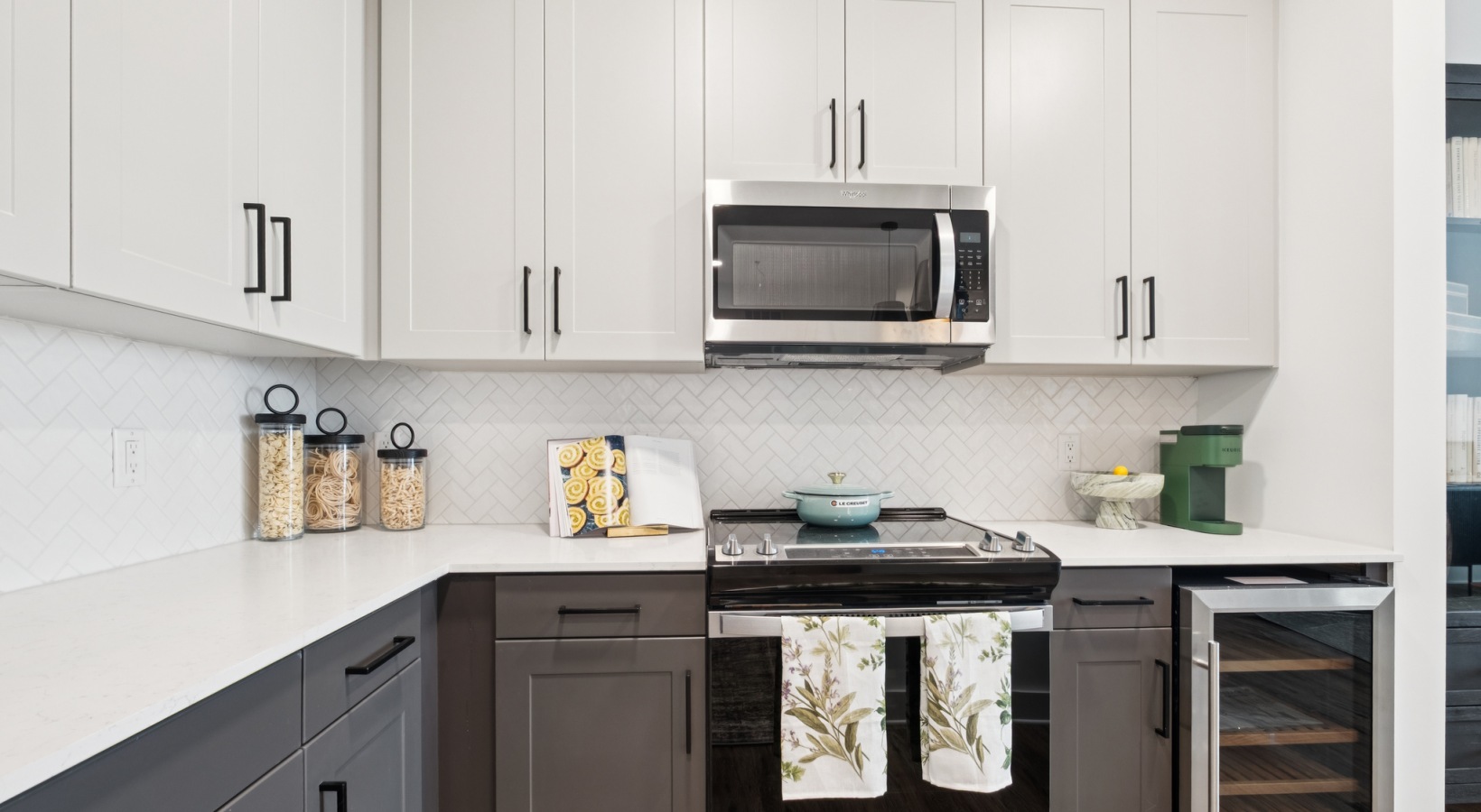 Modern kitchen with sleek cabinetry, a stainless steel microwave, and elegant decor, featuring ample counter space and a stylish oven at The Rowley in Murfreesboro