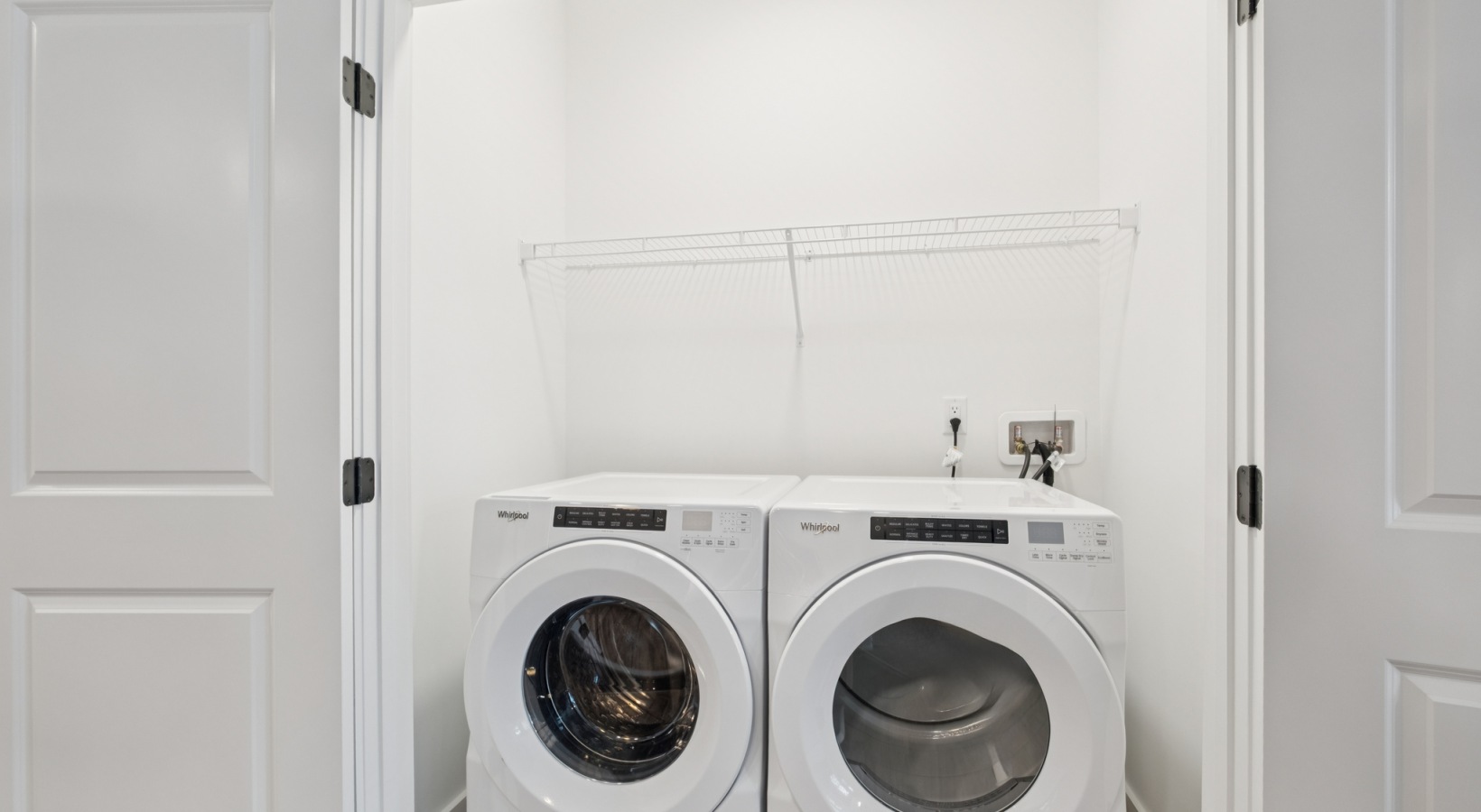 Modern laundry room with sleek Whirlpool washer and dryer units in a bright, compact space at The Rowley in Murfreesboro.