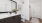 Elegant bathroom featuring sleek dark wood cabinetry, modern fixtures, and a spacious mirror, accented by a serene vase of flowers and tasteful artwork at The Rowley in Murfreesboro