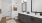 Elegant modern bathroom featuring a sleek double vanity, stylish black fixtures, and warm wood flooring at The Rowley in Murfreesboro