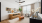 Elegant living room with modern décor, featuring a tan leather sofa, stylish wall art, and a large window with natural lighting. Cozy atmosphere with vibrant plants and a chic wooden coffee table at The Rowley in Murfreesboro